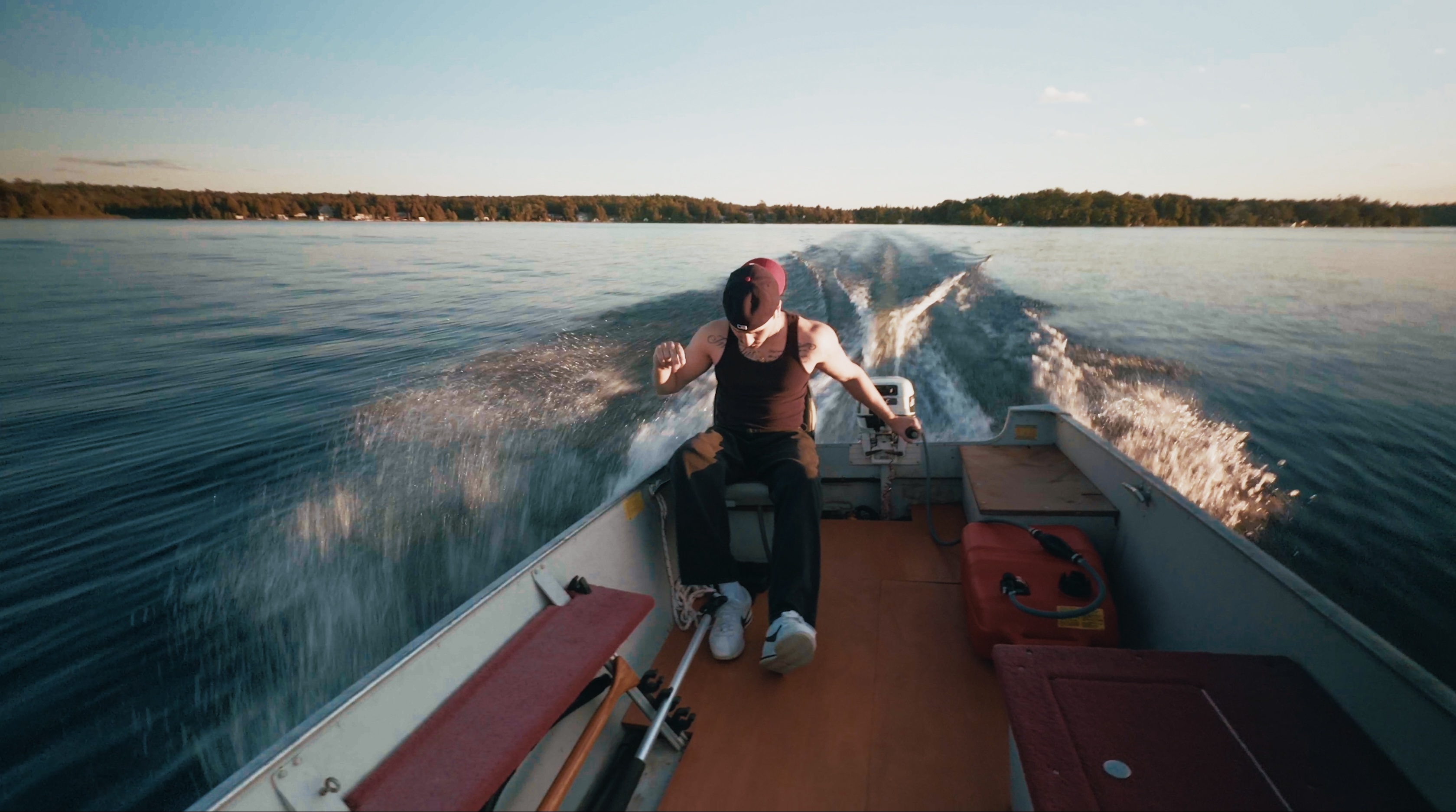 JOZY steering a motorboat across the lake at golden hour